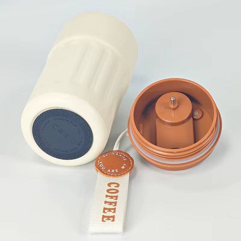 White ceramic mug with blue interior and brown lid on a light gray background